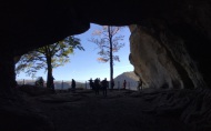 Blick durch eine offene Felsenhöhle in der Sächsischen Schweiz, in der viele Menschen stehen