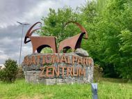 Auf einem Felsen stehen zwei Steinböcke aus Cortenstahl, darunter steht "Nationalparkzentrum"